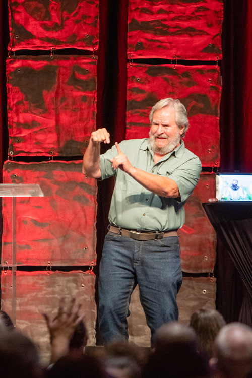 Man using American Sign Language in a presentation on stage